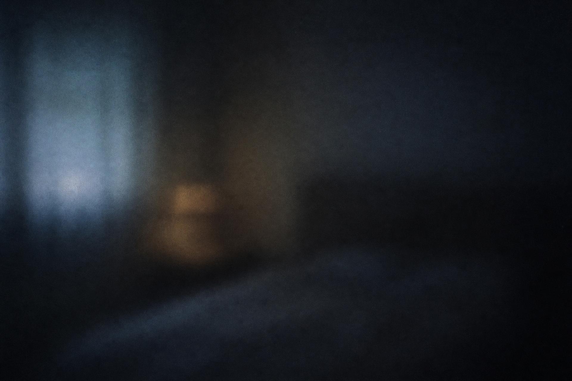 A dim room at night, seen through frosted glass